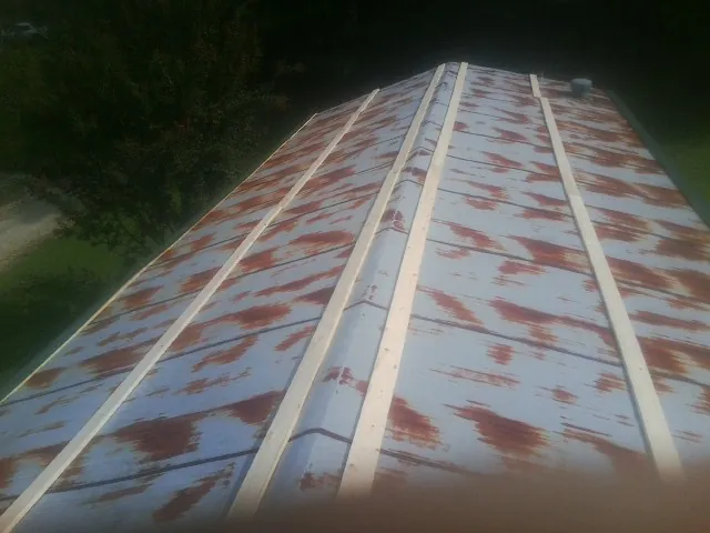 Rusted metal roof panels with new wood purlins before replacement — Storm Damage Roof Repair in Grants Pass by Roofing Brothers