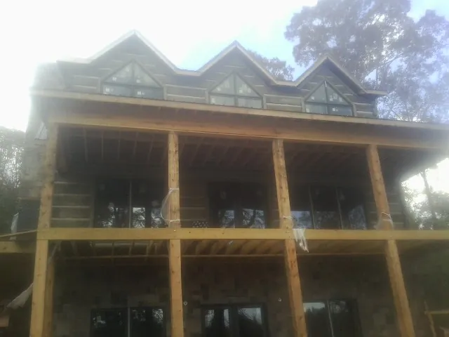 Dormers and porch framing on a large log home under construction — Roof Coating work by our crew in Grants Pass